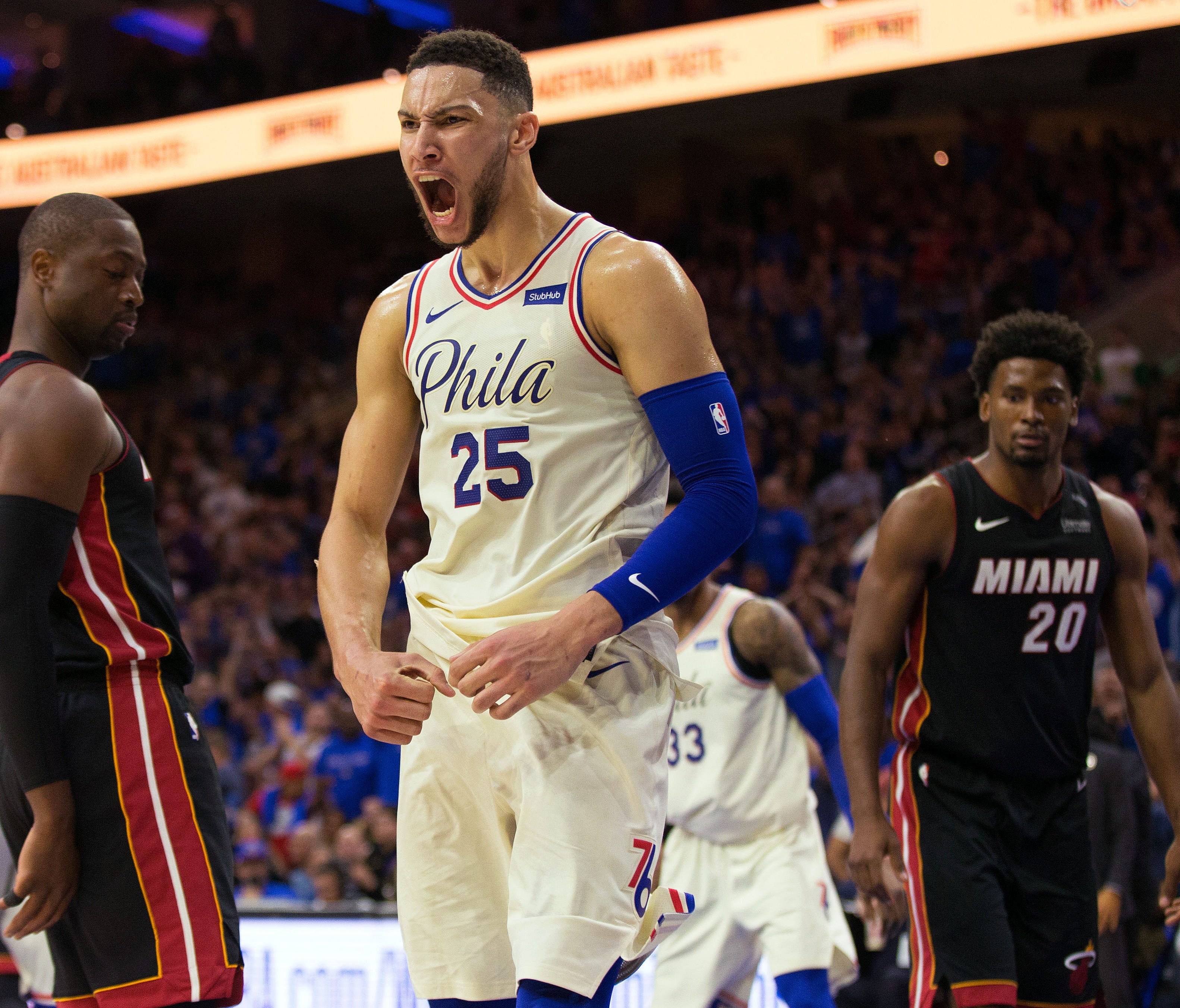 Philadelphia 76ers guard Ben Simmons (25) reacts in front of Miami Heat guard Dwyane Wade (3) and forward Justise Winslow (20) after hi dunk during the third quarter in game one of the first round of the 2018 NBA Playoffs at Wells Fargo Center.