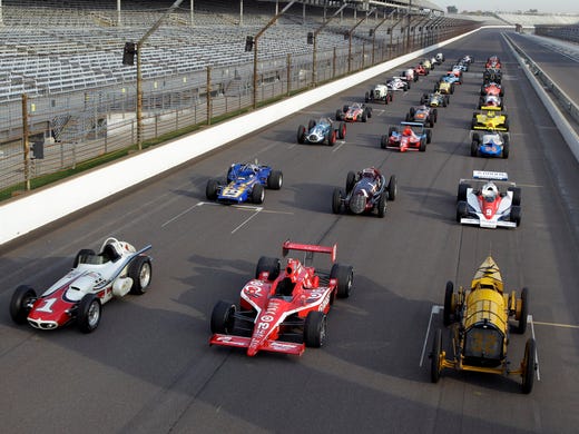 Thirty-three cars driven to victory in the Indianapolis 500 form the staring grid on the main straight during a photo shoot for the 100th anniversary of the Indianapolis Motor Speedway on Oct. 12, 2010. The front row, from right to left, included the 1911 Marmon "Wasp, driven by Ray Harroun, the 2010 car driven by Dario Franchitti, and the 1961 roadster driven by A.J. Foyt for his first of four Indianapolis 500 wins.