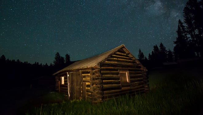 Lit up beneath the night sky, a cabin at Garnet ghost town exposes the remote nature of the 1870s Montana ghost town.