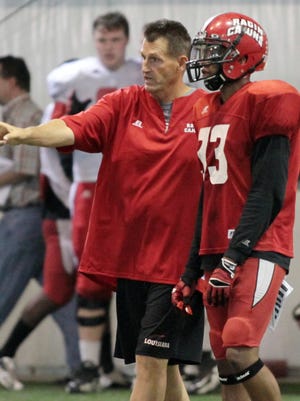 UL safety Trevence Patt (33) gets instruction from cornerbacks coach David Saunders during practice.