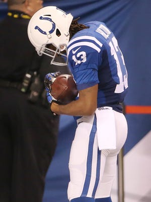 Indianapolis Colts wide receiver T.Y. Hilton cradles the football after his 73-yard touchdown catch in honor of his newborn daughter. Indianapolis hosted Jacksonville at Lucas Oil Stadium on Sunday, November 23, 2014.