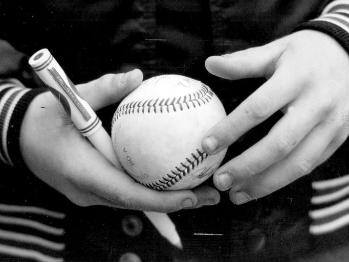 A young fan is ready to gather autographs during the