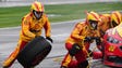 Joey Logano's crew works during a pit stop during the