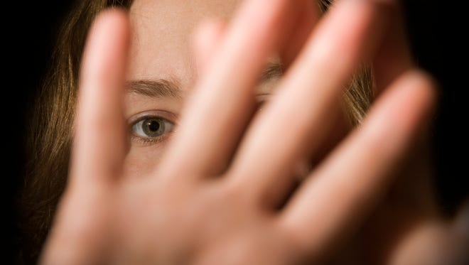 A woman's hands in front of her face.