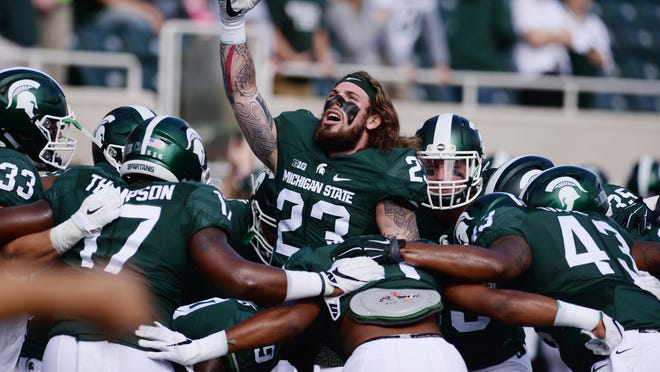 Junior linebacker Chris Frey (23) fires up MSU's linebackers, including Tyriq Thompson (17) and Ed Davis (43) before Saturday's game against Wisconsin.