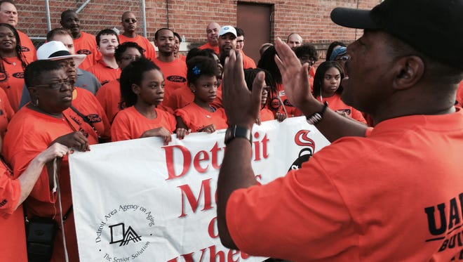 UAW International rep Michael Joseph of Oak Park pulls UAW-Ford volunteers together today in Detroit's Corktown area for a photo after the group filled thousands of boxes of food for Meals on Wheels as part of this weekend's Labor Day outreach