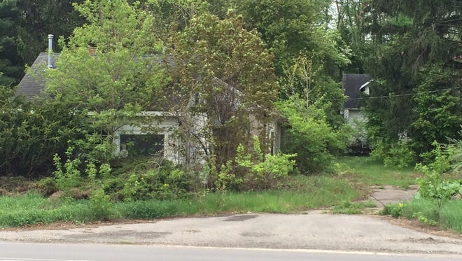 A vacant house and greenhouse sits on the southwest corner of Grand River Avenue and Nicholson Road in Handy Township.