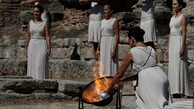 Actress Ino Menegaki as high priestess  lights the Olympic Flame from the sun's rays during the lighting of the Olympic flame at Ancient Olympia in Greece on Sunday.