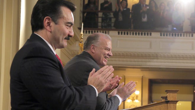 Gov. Chris Christie gestures as he arrives in the Assembly Chamber at the Statehouse in Trenton Tuesday to deliver his annual budget dddress. Also shown are Assembly Speaker Vincent Prieto, left, and Senate President Stephen Sweeney.