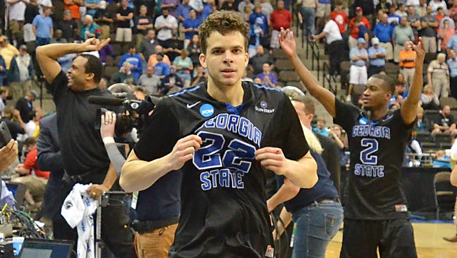 Georgia State's R.J. Hunter (22) comes off the court after making a game-winning shot against Baylor, as head coach Ron Hunter, back left, and Ryann Green (2) celebrate their 57-56 in the second round of the NCAA college basketball tournament, Thursday, March 19, 2015, in Jacksonville, Fla. (AP Photo/Rick Wilson)