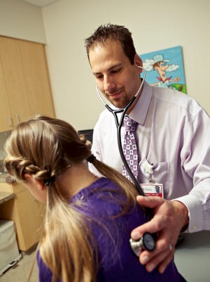Keystone Health pediatrician Dr. Michael Colli listens to a young patient's chest in this submitted photo. Local health care officials met last week to come up with a regional approach to diagnosing and treating new cases.