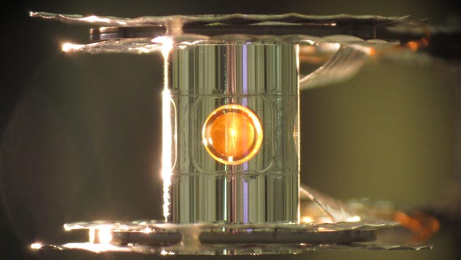 Deze afbeelding van het Lawrence Livermore National Laboratory toont een deuterium- en tritiumcapsule, met een bol in het middenvenster, in een cilindrische hohlraum-container van ongeveer 0,4 inch hoog.