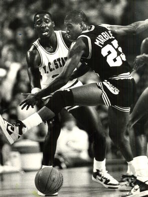 North Carolina State guard Ernie Myers and Iowa guard Roy Marble scramble for a loose ball.