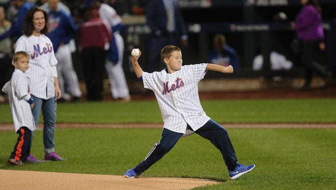 Michael Fahy Jr. whose father, Dpty Chief Michael Fahy died in a fire in the Bronx last month threw out the first pitch in front of his mother and siblings at Citi Field Wednesday October 5, 2016