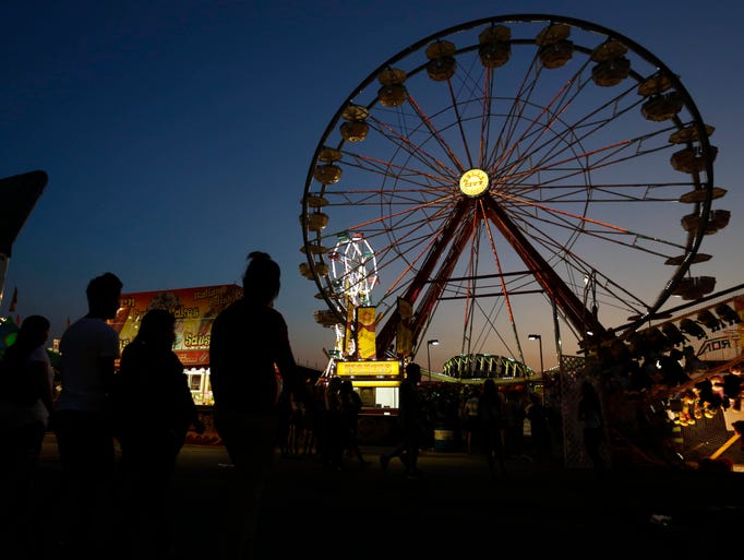 Crowds head to the midway Friday, Aug. 14, 2015, during