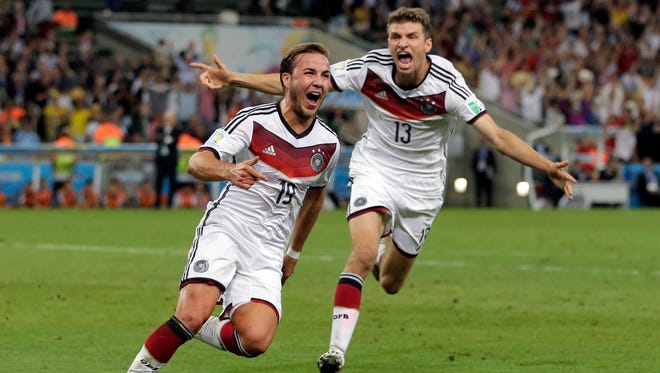 Germany's Mario Goetze (19) celebrates with Thomas Mueller after scoring his side's first goal in extra time against Argentina's goalkeeper Sergio Romero during the World Cup final soccer match between Germany and Argentina at the Maracana Stadium in Rio de Janeiro, Brazil, Sunday, July 13, 2014. (AP Photo/Felipe Dana)