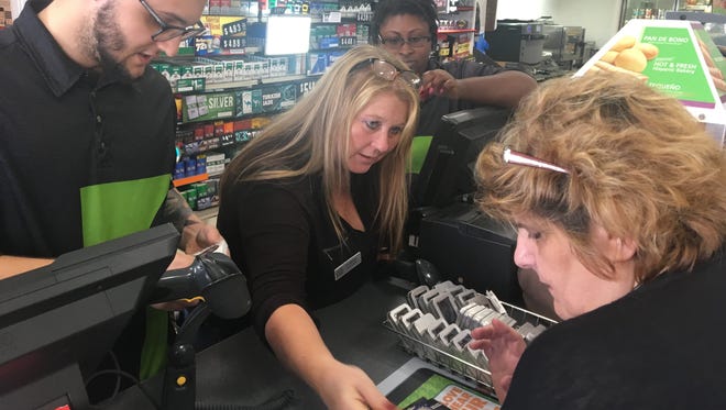 Shannon Moon, manager of the Cape Coral 7-Eleven off Del Prado and Pine Island Road, shows an assortment of fidget spinners to customer Camille Graepel as clerks Justin Irizarry and Ericka Finley look on.