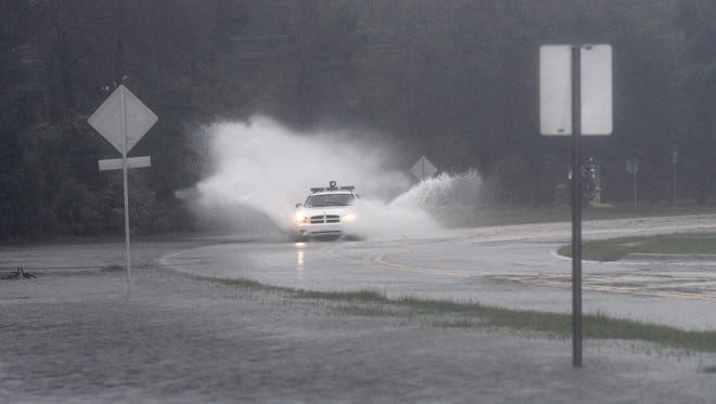 A sheriff's deputy drives through a flooded Viera Blvd. near Holiday Springs Dr.