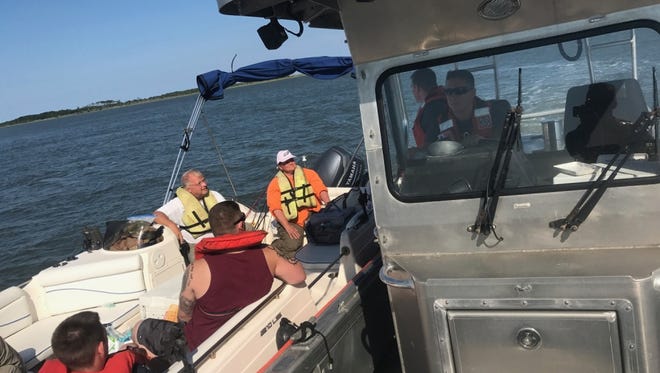 A Coast Guard boat takes the five people rescued off Wachapreague to the town marina.