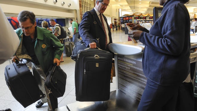 Delta is offering 2,500 bonus miles to existing members of its frequent flier program if checked baggage isn't on the carousel within 20 minutes of the plane arriving at the gate. Passengers check in their luggage at the Delta counter at Hartsfield-Jackson Atlanta International Airport in this 2013 file photo.