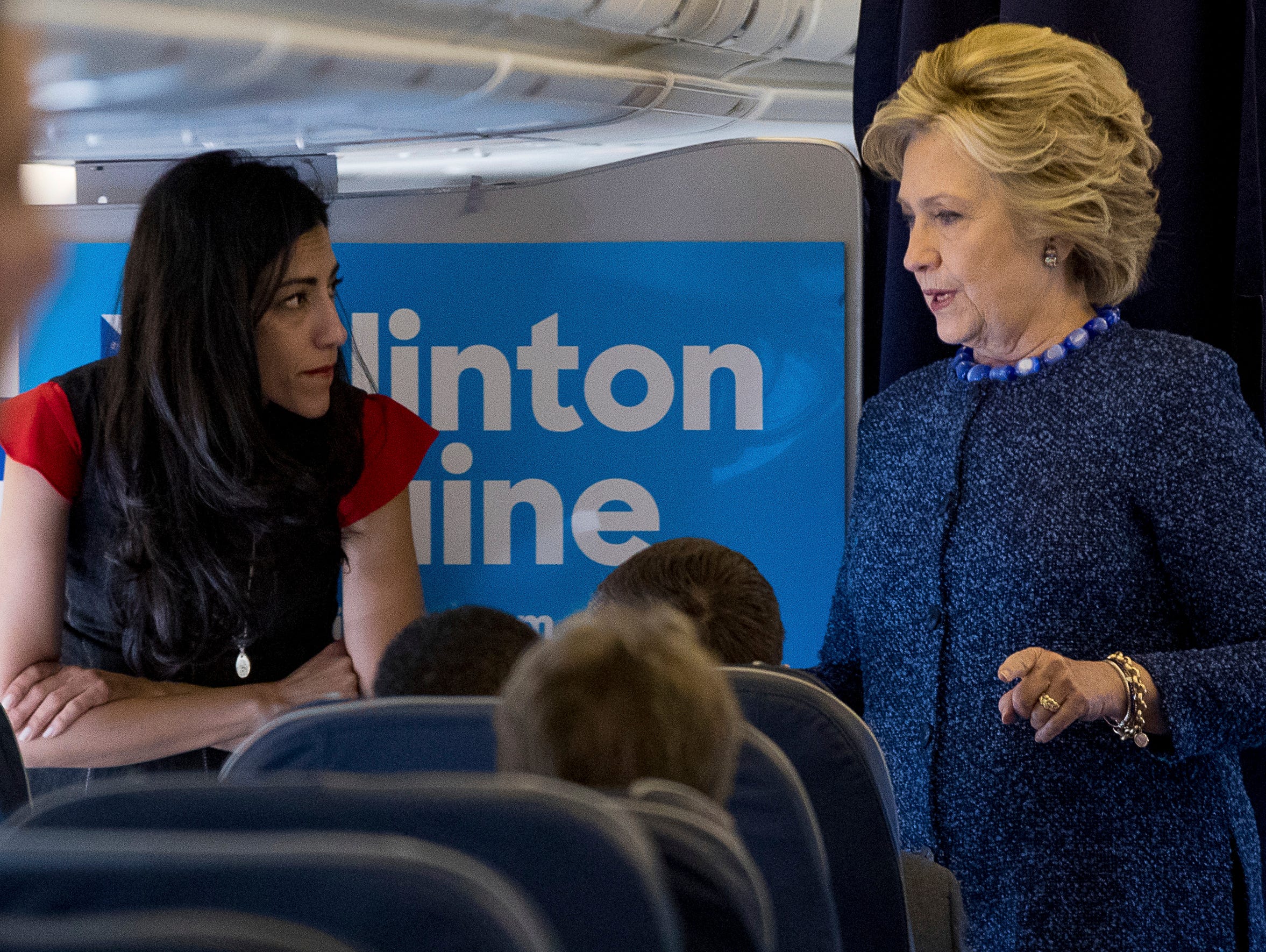 Democratic presidential candidate Hillary Clinton speaks with senior aide Huma Abedin aboard her campaign plane at Westchester County Airport in White Plains on Oct. 28, 2016.