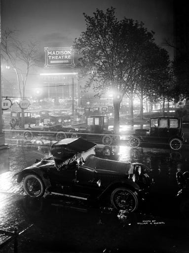 A roadster parks in Grand Circus Park within view of