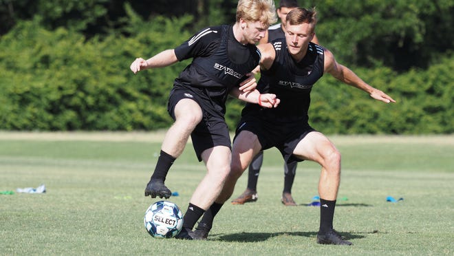 Tormenta FC midfielder Grant Hampton of Savannah controls the ball while being closely marked.