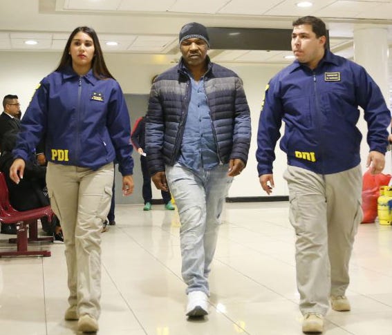 In this photo provided by the Policia de Investigacion de Chile, PDI, officers escort former heavyweight boxing champion Mike Tyson after being denied entry to the country, at the international airport in Santiago, Chile, Thursday, Nov. 9. 2017. Tyso