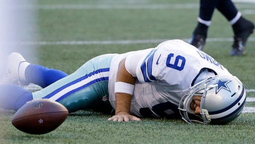 Dallas Cowboys quarterback Tony Romo lies on the turf after he went down on a play against the Seattle Seahawks during the first half of a preseason NFL football game, Thursday  in Seattle.