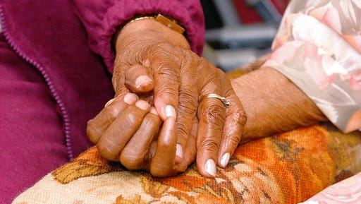 FILE - In this April 1, 2005 file photo, an 81-year-old woman holds the hand of her 100-year-old mother in Tuscaloosa, Ala. A survey conducted in late 2016 finds many pessimistic feelings held by people earlier in life take an optimistic turn as they move toward old age. Even hallmark concerns of old age _ about declining health, lack of independence and memory loss _ lessen as Americans age.