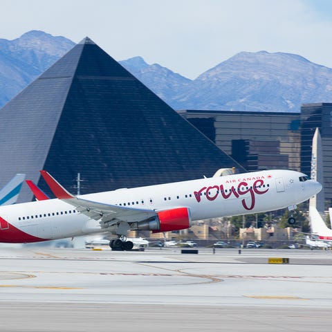 A rouge Boeing 767 leaves the warm climate Las...
