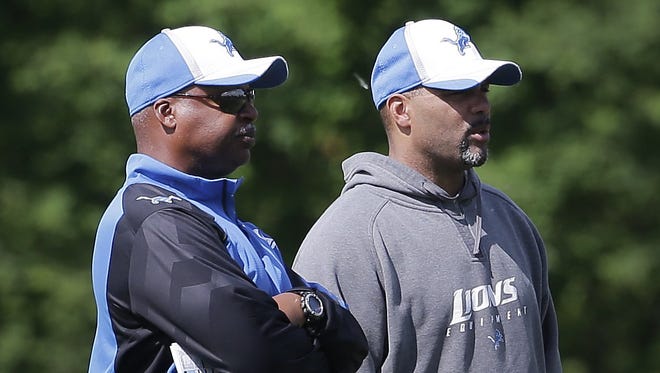 Detroit Lions head coach Jim Caldwell talks with defensive coordinator Teryl Austin, right, during practice in Allen Park on June 3, 2014.
