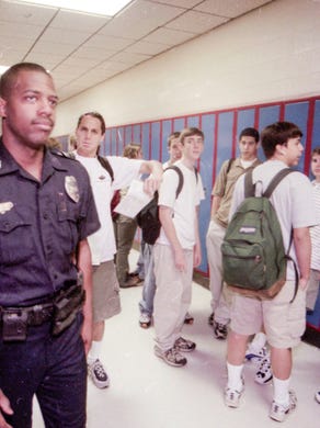 Knoxville Police officer Erik Reeves walks the halls at West High School in April of 1999 as students take in the presence of the officer in the wake of the Columbine High School shooting.