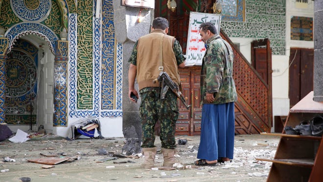 Shiite fighters, known as Houthis inspect the inside of the al-Balili mosque after two suicide bombings at the mosque during Eid al-Adha prayers in Sanaa, Yemen, Thursday, Sept. 24, 2015.