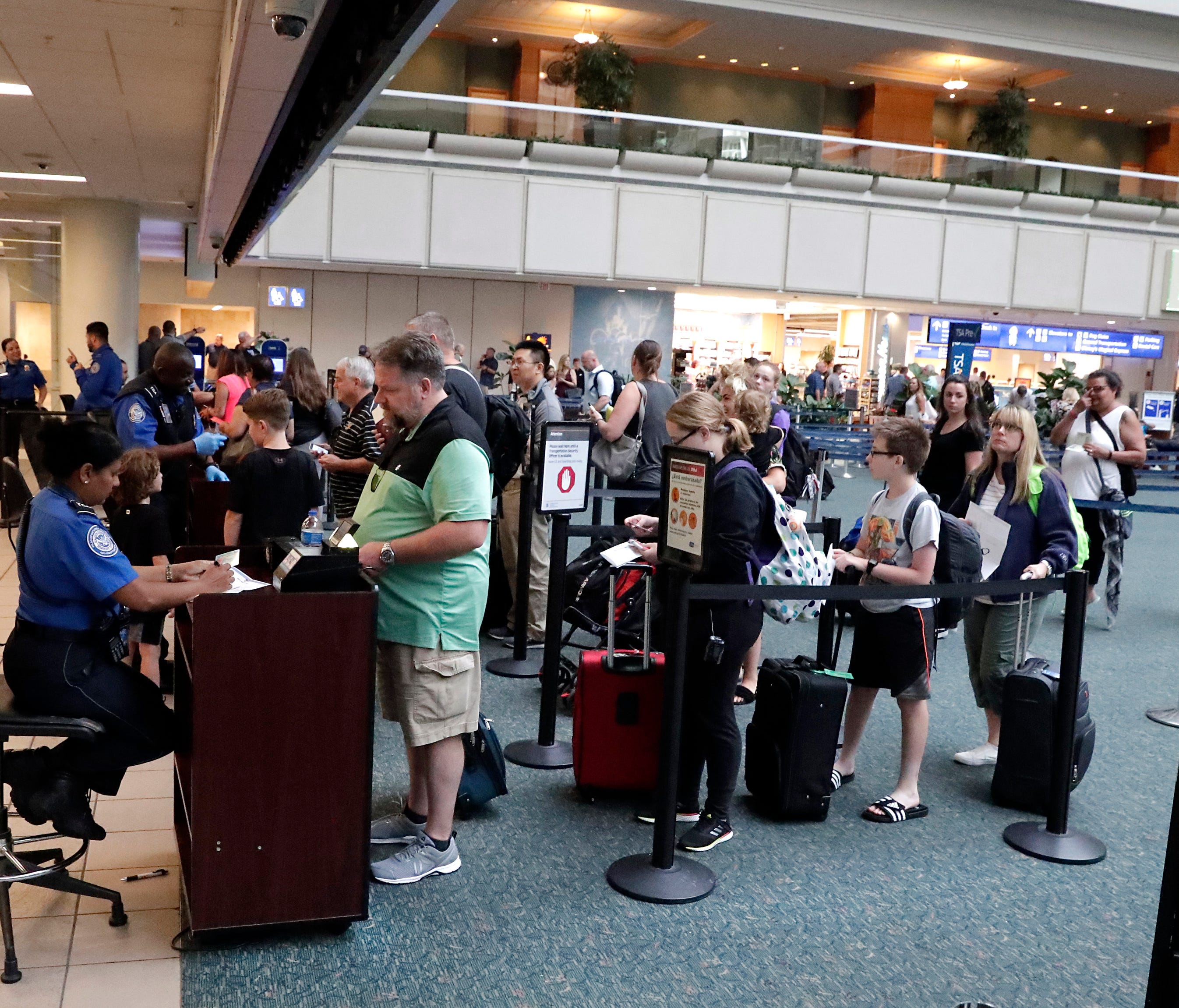 Air passengers heading to their departure gates enter Transportation Security Administration Precheck line before going through security screening at Orlando International Airport on June 21, 2018, in Orlando, Fla.