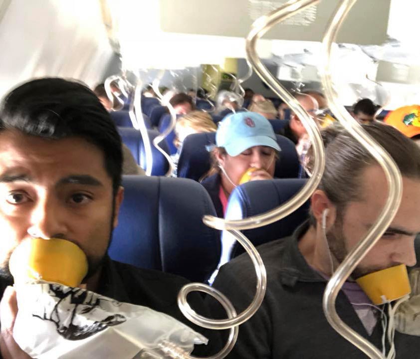 In this April 17, 2018 photo provided by Marty Martinez, Martinez, left, appears with other passengers after a jet engine blew out on the Southwest Airlines Boeing 737 plane he was flying in from New York to Dallas.