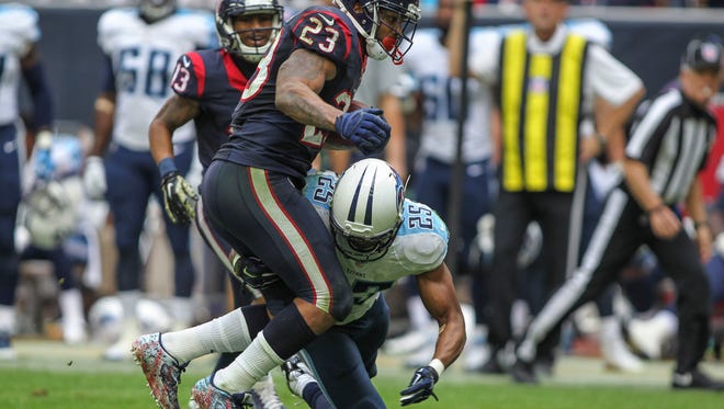 Titans cornerback Blidi Wreh-Wilson tries to tackle Texans running back Arian Foster on Sunday in Houston.