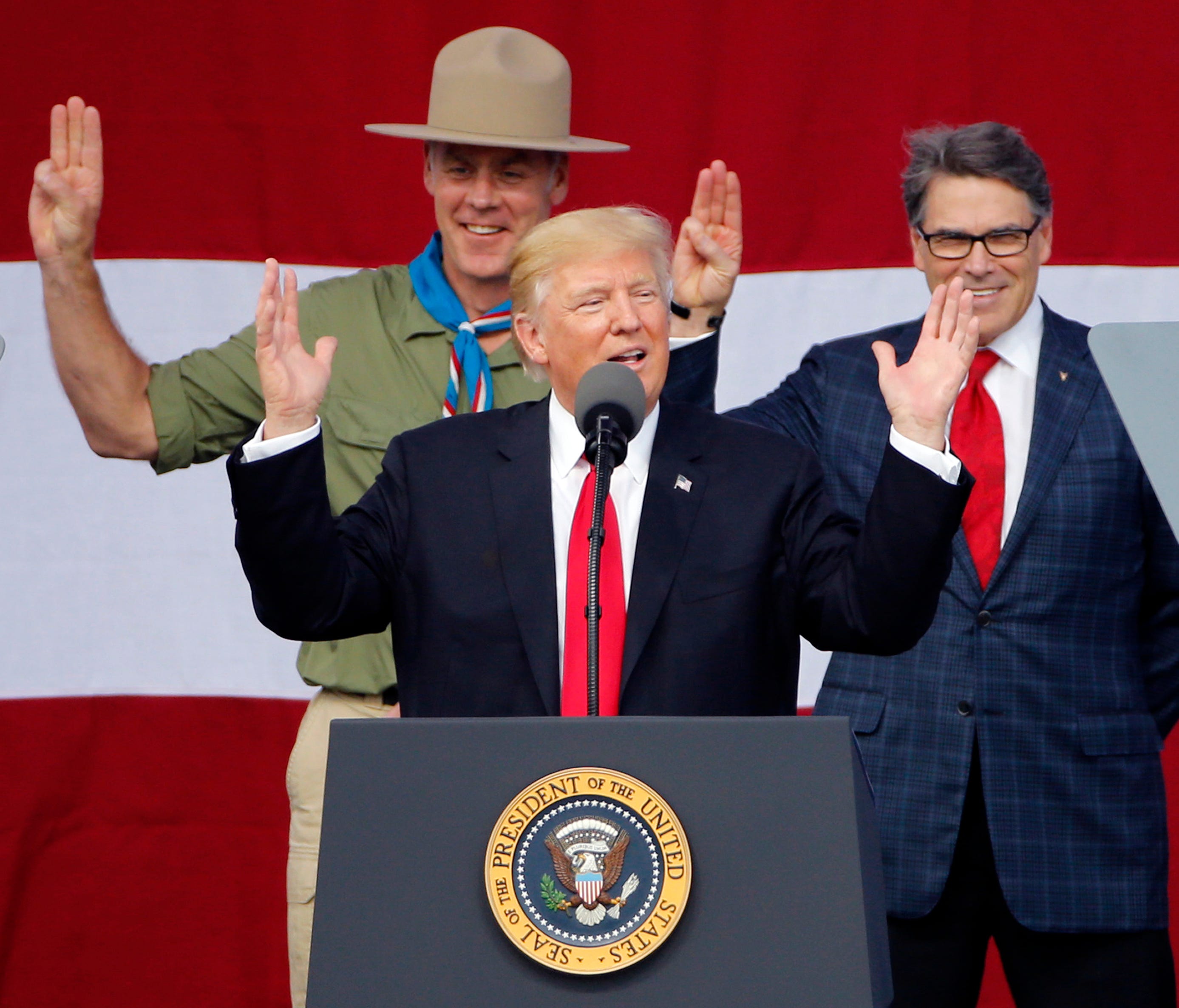 President Trump gestures as former Boy Scouts, Interior Secretary Ryan Zinke, left, Energy Secretary Rick Perry, watch at the 2017 National Boy Scout Jamboree at the Summit in Glen Jean,W. Va.,  July 24, 2017.