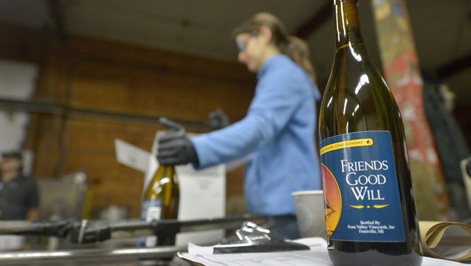Jaque Miralda packages bottles of chardonnay at Fenn Valley Winery on Monday.