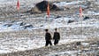 A pair of North Korean soldiers walk through a field