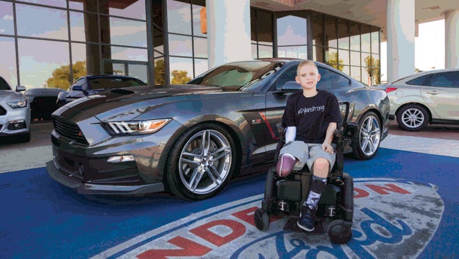 Dylan Darland in front of a 2016 ROUSH Stage 3 Ford Mustang that is being raffled to raise funds for his recovery after a boating accident