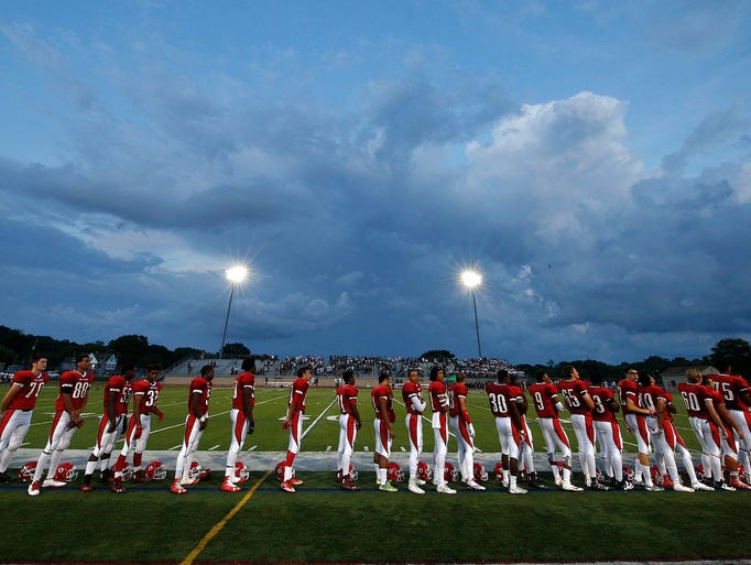 The Wauwatosa East football team stands for the playing