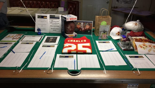 A pool table inside Carl's Place was covered with silent auction items to raise money for the two police officers who were killed in the squad cars earlier this month. The fundraiser raised nearly $10,000.