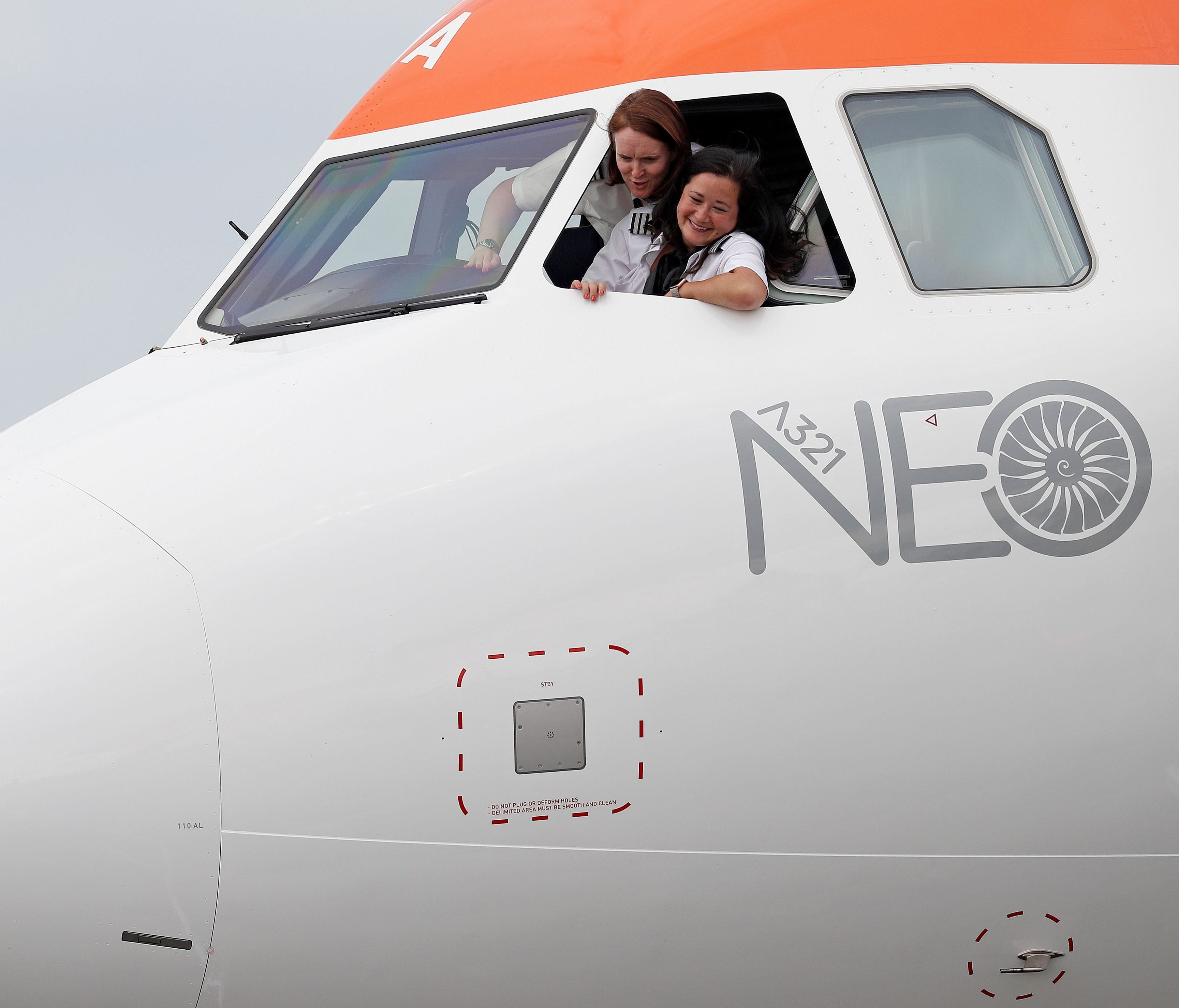 EasyJet pilots pose from the cockpit of the carrier's new Airbus A321neo aircraft at the Farnborough Airshow on July 18, 2018.