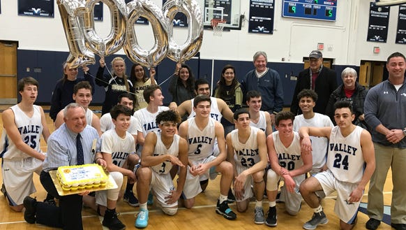 Joe Leicht, kneeling wearing tie, receives balloons