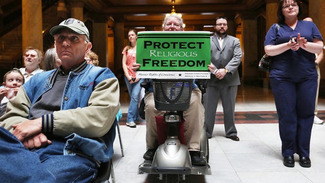 Cindy Holmes, Mechanicsburg, holds up a sign at the Indiana Pastors Alliance rally in the north atrium of the Indiana Statehouse on Monday, April 27, 2015. More than 150 people showed up to express their opposition to the changes Indiana lawmakers made to the Religious Freedom Restoration Act that Gov. Mike Pence signed earlier this month.