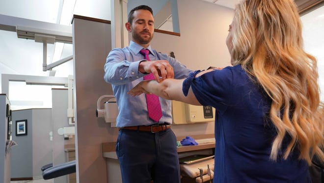 Ryan Robinson, dentist at Pike Creek Dental, test the reflexes of patient Michelle Pietlock, of Hockessin, who is being treated for sleep apnea that was diagnosed through test done by Robinson's dental firm.
