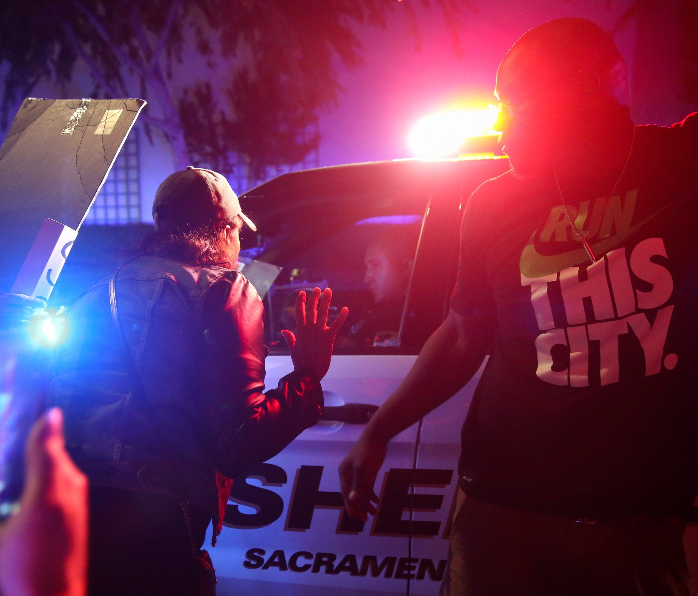 Protesters confront law enforcement officers in the street after a woman was struck by a Sacramento Sheriff's Department vehicle.