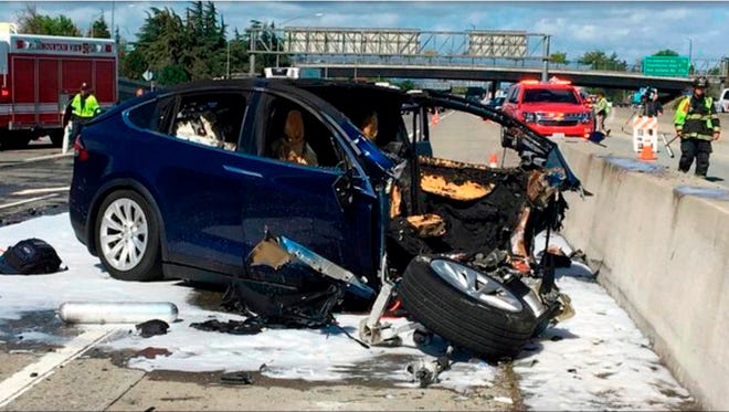 In this March 23, 2018, file photo provided by KTVU, emergency personnel work at the scene where a Tesla electric SUV crashed into a barrier on U.S. Highway 101 in Mountain View, Calif. Federal safety investigators have booted electric car maker Tesla Inc. from the group investigating a fatal crash in California that involved an SUV operating with the company's Autopilot system. The National Transportation Safety Board said Thursday, April 12, it removed Tesla as a party to the investigation after the company prematurely made information public. (KTVU via AP, File)