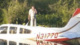 The pilot of a small plane stands outside after crashing it into a swamp near the Danbury Municipal Airport in Connecticut.